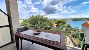 een balkon met een tafel en uitzicht op het water bij Ceratonia Apartments in Lovište