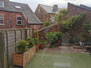 einen Garten mit Topfpflanzen und einem Zaun in der Unterkunft Entire house Sheffield s10booking in Stannington