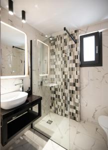 een badkamer met een wastafel en een douche bij Dom in Lefkada