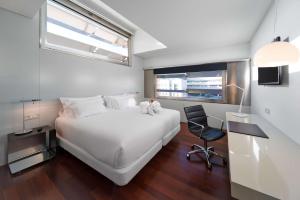sypialnia z dużym białym łóżkiem i oknem w obiekcie NH Collection Barcelona Constanza w Barcelonie