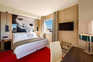 a hotel room with a large bed and a window at NH Collection Madrid Suecia in Madrid