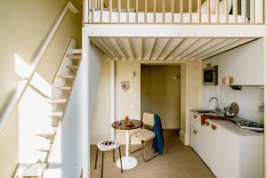a small kitchen with a table and a loft bed at Mason & Fifth, Primrose Hill in London