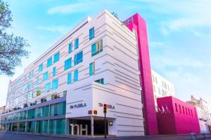 un edificio blanco con un color rosa en NH Puebla Centro Histórico, en Puebla