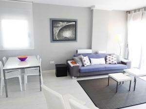 - un salon avec un canapé bleu et une table dans l'établissement Apartment Marenia by Interhome, à Dénia