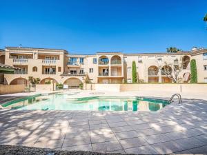 a swimming pool in front of a building at Apartment Caesar Domus-1 by Interhome in Saint-Tropez