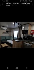 una cucina e un soggiorno con divano di Vacances contis plage a Saint-Julien-en-Born Altre 4 foto