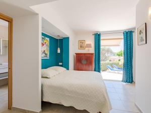 サント・マキシムにあるHoliday Home Villa Bindouletto by Interhomeのベッドルーム1室(青い壁のベッド1台、窓付)