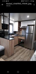 una cucina con frigorifero in acciaio inossidabile e pavimenti in legno di Vacances contis plage a Saint-Julien-en-Born