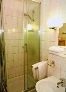 Un baño con ducha, lavabo e inodoro. en Haus Nicolai FeWo 8, en Baabe