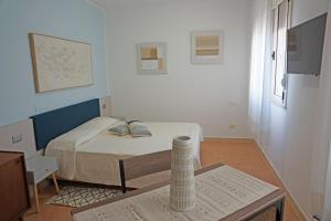 mały pokój z łóżkiem i stołem w obiekcie Residence La Rosa di Nettuno w mieście Marina di Grosseto
