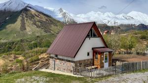 uma pequena casa com um telhado castanho numa montanha em Cottage Gudauri em Gudauri