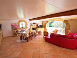 Holiday Home Cucuron by Interhome في كوكورون: غرفة معيشة مع أريكة حمراء وطاولة