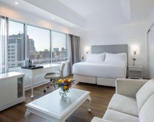 a hotel room with a bed and a desk at NH Collection Plaza Santiago in Santiago