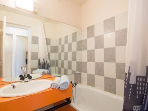 ein Badezimmer mit Waschbecken, Badewanne und Spiegel in der Unterkunft Apartment Pegase Phenix-35 by Interhome in Le Corbier