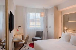 um quarto de hotel com uma cama, uma secretária e uma cadeira em NH Collection Roma Centro em Roma