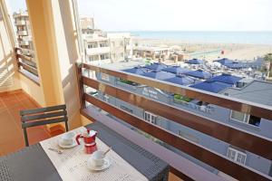 balkon ze stołem i widokiem na plażę w obiekcie Residence La Rosa di Nettuno w mieście Marina di Grosseto