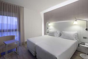 ein Schlafzimmer mit einem großen weißen Bett und einem Fenster in der Unterkunft NH Milano Congress Centre in Assago