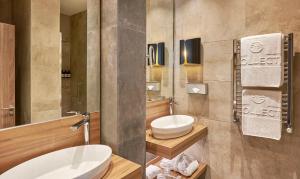 a bathroom with two sinks and a toilet in it at NH Collection Madrid Gran Vía in Madrid