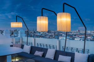 a living room with a couch and three lights at NH Collection Madrid Gran Vía in Madrid
