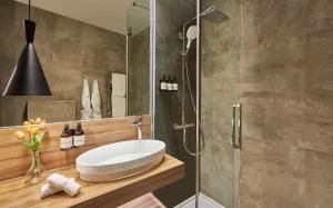 a bathroom with a sink and a shower at NH Collection Madrid Gran Vía in Madrid