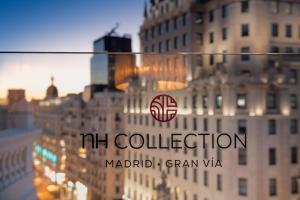a reflection of a building with a marriott collection sign on it at NH Collection Madrid Gran Vía in Madrid