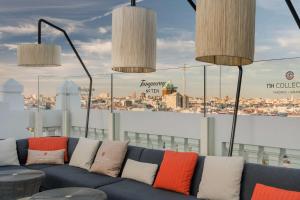 a blue couch with colorful pillows on top of a building at NH Collection Madrid Gran Vía in Madrid