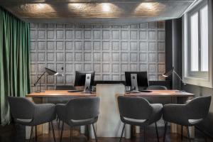 a conference room with two desks with computers on them at NH Collection Madrid Gran Vía in Madrid