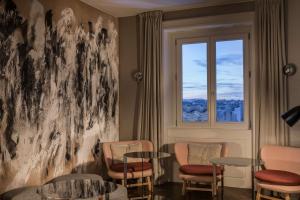 a waiting room with two tables and a window at NH Collection Madrid Gran Vía in Madrid