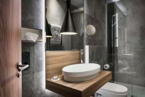 a bathroom with a toilet and a sink and a shower at NH Collection Madrid Gran Vía in Madrid