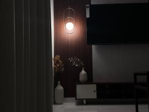 a room with a light on the wall and two vases at شقة حي العقيق قريبة البوليفارد in Riyadh