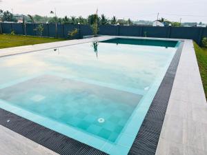 a swimming pool in a backyard with blue water at Liyadi Addalaichenai in Addalachenai