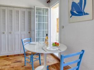 une salle à manger avec une table blanche et des chaises bleues dans l'établissement Apartment Hameau la Madrague-8 by Interhome, à La Madrague