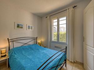 ナルボンヌ・プラージュにあるHoliday Home Les Grandes Bleues 2-1 by Interhomeのベッドルーム(青いベッド1台、窓付)