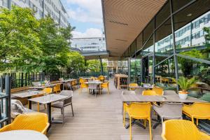 a restaurant with yellow chairs and tables and windows at Première Classe Lyon Centre Gare Part Dieu in Lyon