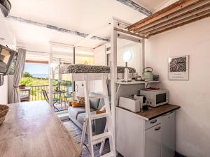 a room with a bunk bed and a kitchen with a microwave at Studio Casa Maza Corta by Interhome in Lumio