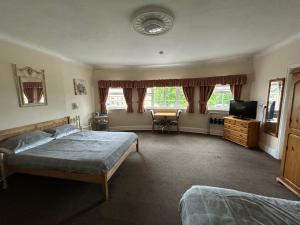 a bedroom with two beds and a flat screen tv at Blue Boar Inn in Atherstone