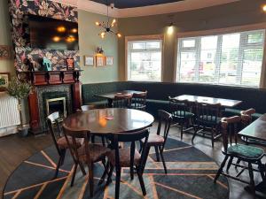 um restaurante com mesas e cadeiras e uma lareira em Blue Boar Inn em Atherstone