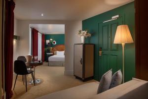uma sala com um quarto com uma cama e uma mesa em NH Paris Opéra Faubourg em Paris