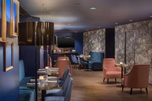 un ristorante con pareti e tavoli blu e sedie di NH Paris Champs-Elysées a Parigi