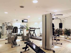 einen Fitnessraum mit mehreren Laufbändern und Heimtrainern in der Unterkunft Mercure Hotel Hannover City in Hannover