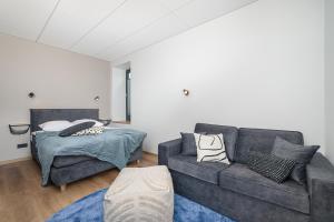 een woonkamer met een bank en een bed bij Betooni Stay in Tartu