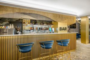 a bar with blue bar stools in a restaurant at Kenese Bay Garden Resort & Conference in Balatonkenese