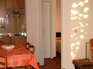 kuchnia i jadalnia ze stołem oraz pokój z kuchnią w obiekcie Apartment Novi by Interhome w mieście Krnica