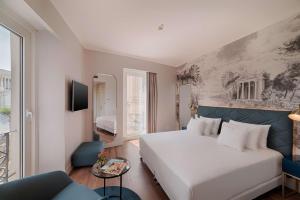 une chambre d'hôtel avec un lit et un canapé dans l'établissement NH Collection Roma Fori Imperiali, à Rome