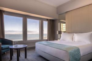 a hotel room with a large bed and windows at Tivoli Oriente Lisboa Hotel in Lisbon