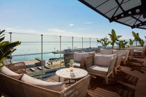 Tivoli Oriente Lisboa Hotel في لشبونة: فناء مع كراسي وطاولات وإطلالة على المحيط