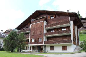 a large apartment building with a wooden roof at Le Castel 1 in Chateau-d'Oex