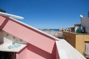 a sink on the side of a pink building at Charming House in Castellammare del Golfo with Balcony in Castellammare del Golfo