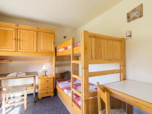 a bedroom with two bunk beds and a desk at Apartment Pegase Phenix-38 by Interhome in Le Corbier