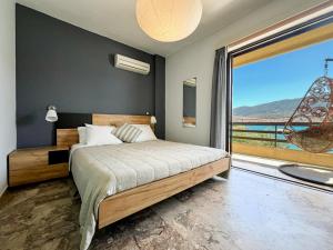 a bedroom with a bed and a large window at Villa Irene in Poros